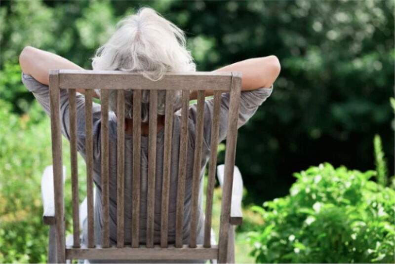 Ältere Person entspannt in einem Gartenstuhl